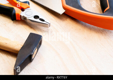 Hammer, nails and pliers lie on a wooden background. Construction Tools Selective Focus Stock Photo