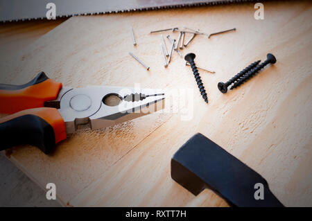 Hammer, nails and pliers lie on a wooden background. Construction Tools Selective Focus Stock Photo