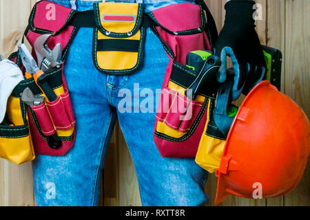 Tools in the belt for tools. The builder holds a helmet. Selective focus Stock Photo