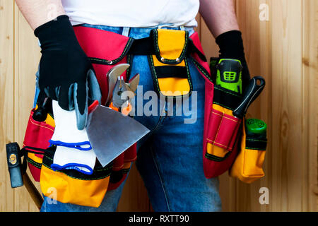 Tools in the belt for tools. The builder holds a spatula in his hand. Selective focus Stock Photo