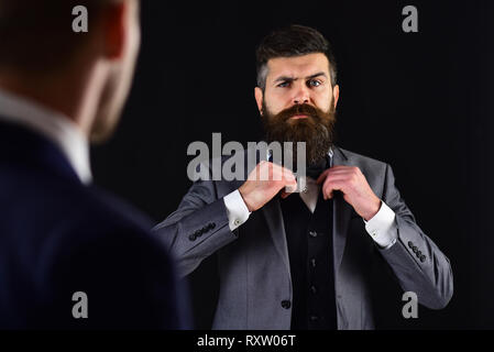 Meeting of reputable businessmen, black background. Man with beard on serious face, ties bow tie before meeting. Business meeting concept. Businessmen Stock Photo