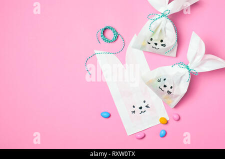 Bunny Paper Bags and Chocolate Eggs, Easter Sweet Treats, Kids Party Idea, Top View Stock Photo