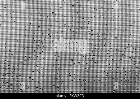 Raindrops on a window screen form an abstract background Stock Photo