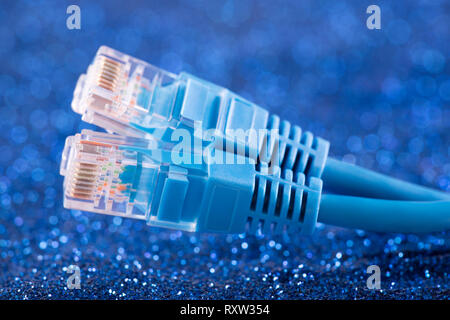 Two network cables over blue sparkles background Stock Photo