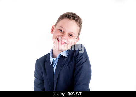 Boy in a blue shirt and a jacket smiles friendly into the camera Stock Photo