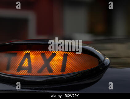 Taxi sign on the roof of a car at night Stock Photo