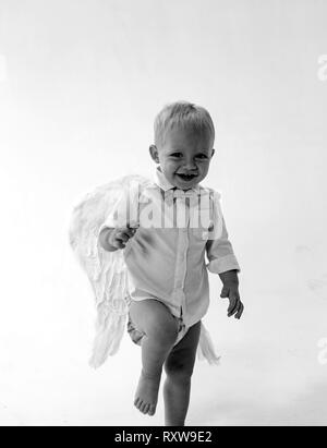 Lets celebrate. Adorable little angel boy. Baby angel. Little boy with angel wings and halo. Cute valentines cupid or cherub baby. Christmas angel Stock Photo