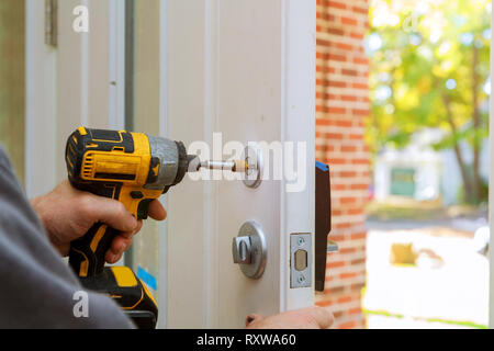 worker's hands installing new door locker man repairing the doorknob. closeup Stock Photo
