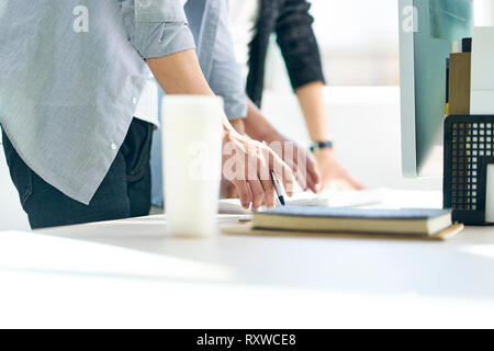 two young asian business people working together in front of desktop computer in office. Stock Photo