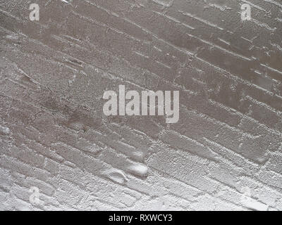Ridges and crystals on a frosty window in a silver gray color, making an abstract pattern. Stock Photo