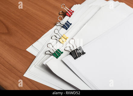 White paper document template with metal color clips on work table side view Stock Photo