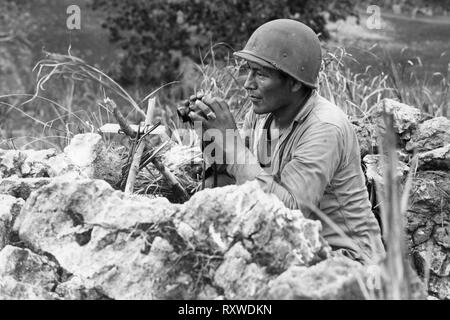 Navajo Indian code-talker Pfc Carl Gorman of Chinle, Arizona, manning an observation post on a hill overlooking the City of Garapan, while the U.S. Marines were consolidating their positions on the Island of Saipan, Marianas on June 27, 1944 During the Battle of Saipan. Stock Photo
