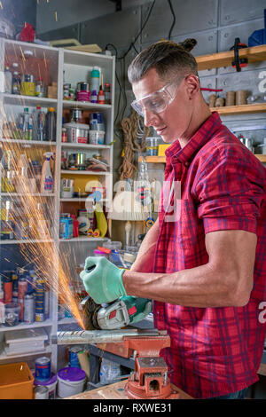 Locksmith cuts metal with a grinding machine, Mechanic power saw cuts. Stock Photo