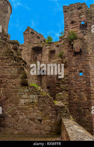 Great view from inside the bailey ruins of Hanstein Castle on a nice day with blue sky. Plants are growing on the red bricks. It is considered one of... Stock Photo
