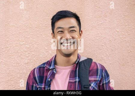Cool happy man standing outside against the wall Stock Photo