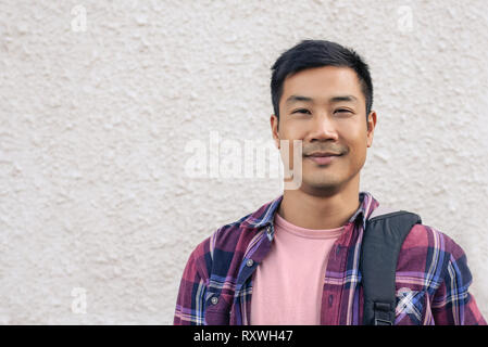 Handsome Asian man standing outside in the city Stock Photo
