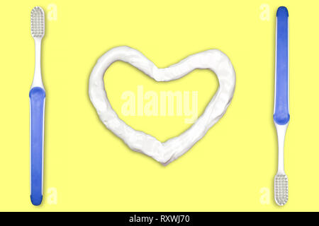 Toothbrush and heart shaped toothpaste. Concept for Healthy Dental Campaign. We love to brush our teeth. Isolate on yellow background. Stock Photo
