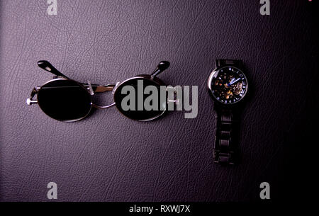 glasses and clock in the style of steampunk on a black background. Stock Photo