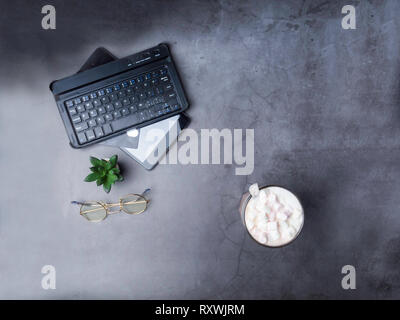 Modern working place on grey table. Working place keyboard, notepad, coffee, glasses, cactus Stock Photo