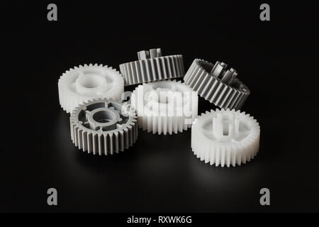 three gray and three white plastic gears on a dark background closeup Stock Photo