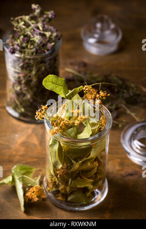 Dry linden flowers in a glass jar, top view Stock Photo