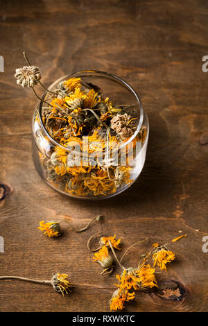 Dry calendula flowers in a glass jar, top view Stock Photo