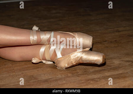 Ballerina's legs shod in pink pointe shoes close-up Stock Photo