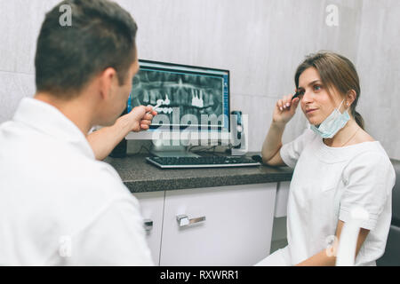 Two concentrated dentists looking at x-ray on computer Stock Photo