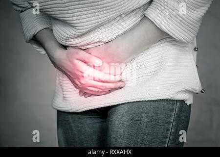 Closeup of a woman having a stomachache. Menstruation of women. The concept of girl need to go to the toilet. copy space. Illness concept. Stock Photo