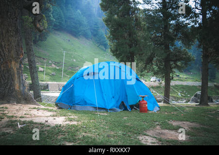 Moody photo of tents set up for camping in the Himalayan region of Kashmir with an LPG stove in front of it Stock Photo