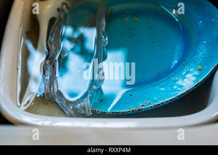 Unwashed dirty dishes soaking in a sink. Stock Photo