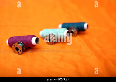 Spool of thread and bobbins. Isolated on the yellow background. Stock Photo