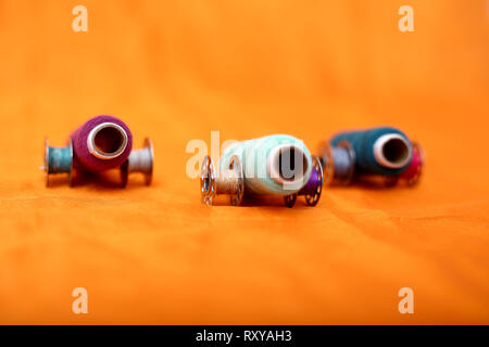 Portrait of Colored thread and bobbins. Isolated on the yellow background. Stock Photo
