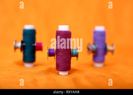 Spool of thread and bobbins. Isolated on the yellow background. Stock Photo