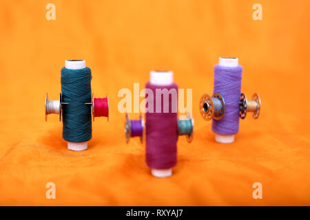 Picture of thread and bobbins. Isolated on the yellow background. Stock Photo