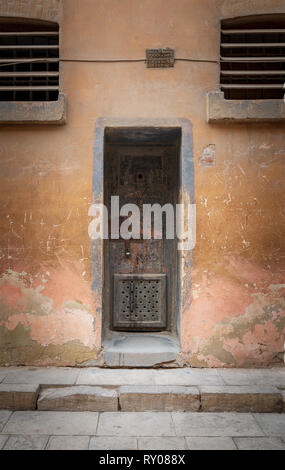 Closed rusted iron cell door and weathered grunge stone wall in closed abandoned prison at Cairo Citadel, Egypt Stock Photo