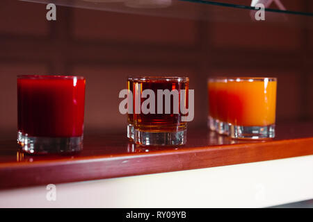 Set of different juice and cocktails on self in bar. Stock Photo