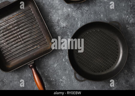 Set of old grill pans on dark stone background top view Stock Photo