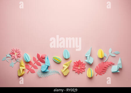 Easter holiday creative background with papercraft eggs, flowers, origami bunny on coral pink background, trendy paper craft holiday springtime backgr Stock Photo