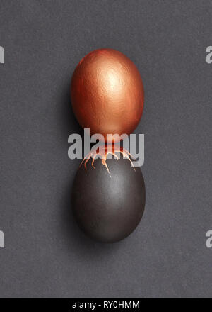 Black and gold colored eggs presented on a black background with copy space. Easy enrichment concept. Flat lay Stock Photo