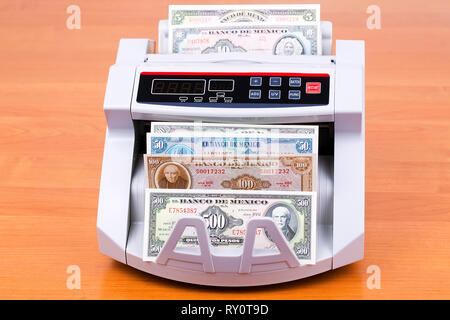 Old Mexican Peso in a counting machine Stock Photo