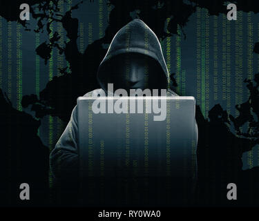 Hacker in black hoodie holding laptop with his hand and world map with binary code over dark background Stock Photo