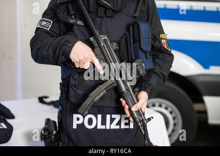 Mainz, Germany. 11th Mar, 2019. An officer of the Evidence Preservation and Arrest Unit (BFE) of the riot police is standing in front of a police vehicle with his new equipment. From the second half of 2019, the first SFOE officers of the Rhineland-Palatinate police are to be specifically trained for close cooperation with special task forces, for example in terrorist situations. Credit: Andreas Arnold/dpa/Alamy Live News Stock Photo