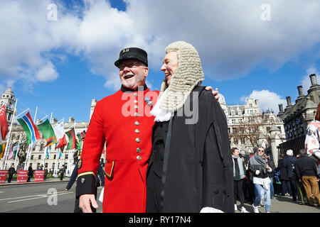 London, UK. 11th Mar, 2019. 11th March 2019.  Newly appointed Queens Counsels, Silks,  at the Palace of Westminster following the swearing in ceremony in London, England.   A QC poses with a Chelsea Pensioner Credit: Thomas Bowles/Alamy Live News Stock Photo