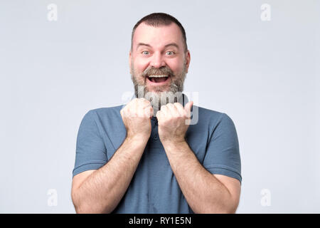 Excited bearded man standing with fists up Stock Photo