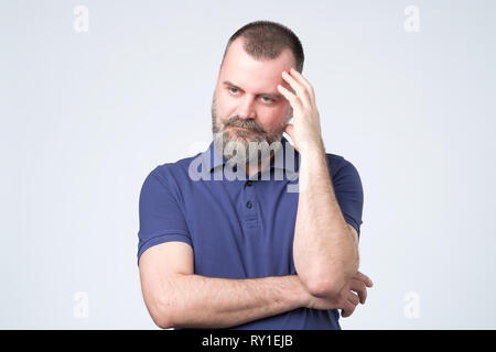 Mature age, problem and people concept. Bearded man in blue clothes thinking Stock Photo