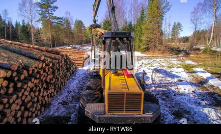 Aerial shot of the forest harvester grabbing the big logs in the ground Stock Photo