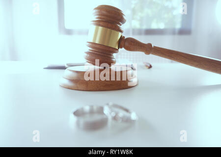 wedding rings and Judge gavel hammer on Lawyer desk for family separation, divorce concept Stock Photo