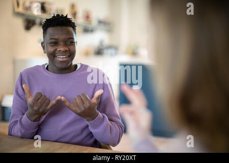 Teenage Boy And Girl Having Conversation Using Sign Language Stock Photo