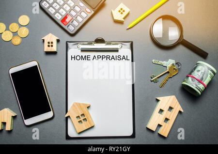 Table with wooden houses, calculator, coins, magnifying glass with the word Home appraisal. The contract for real estate appraisal. Rate the property. Stock Photo